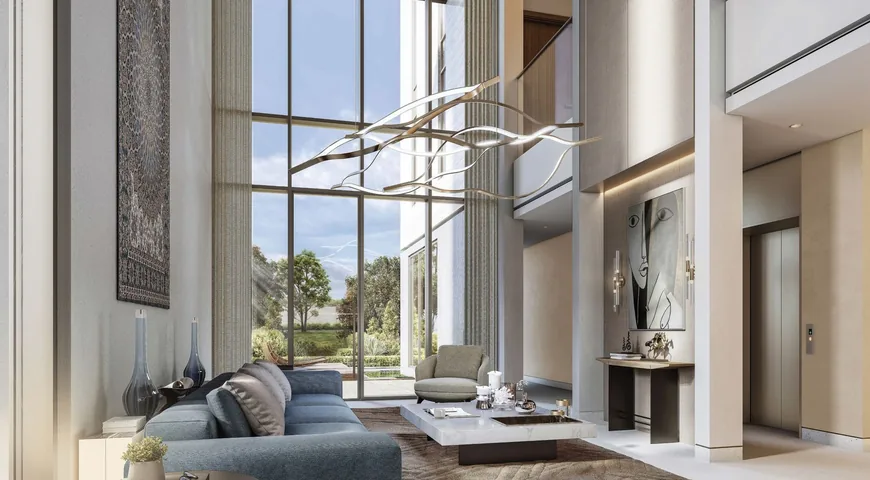 Double-height living room in a villa at Sobha City, with full-height glazing onto the garden